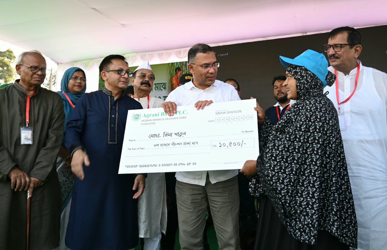 রাজশাহীর মাদ্রাসা মাঠে আখচাষিদের প্রণোদনা বিতরণ অনুষ্ঠানে প্রতীকী চেক হস্তান্তর করছেন প্রধানমন্ত্রী তারেক রহমান। ছবিটি ২০ অক্টোবর ২০২৬ সালের অনুষ্ঠানের।